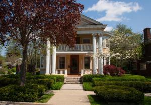 ein weißes Haus mit Säulen und einer Veranda in der Unterkunft Showers Inn in Bloomington