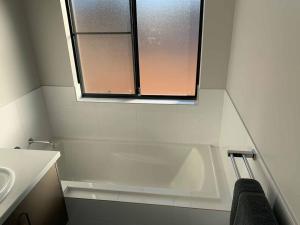 a bathroom with a tub and a sink and a window at Manjimup Gateway Hotel in Manjimup