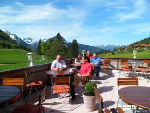 a group of people sitting at tables on a patio at Zum Senn - Hotel und Wirtshaus in Bad Hindelang