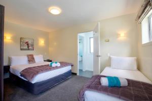 Un pat sau paturi într-o cameră la Caples Court Motel & Apartments