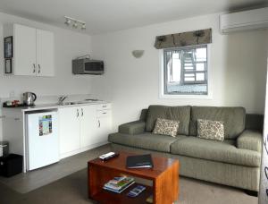 a living room with a couch and a kitchen at Caples Court Motel & Apartments in Queenstown