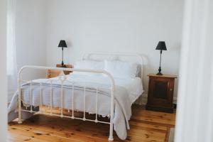 a bedroom with a white bed with white sheets and pillows at Dubuque Bed and Breakfast in Numurkah