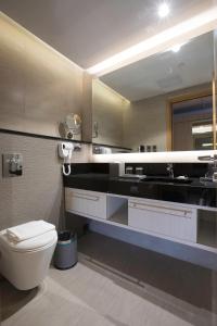 a bathroom with a toilet and a sink at bai Hotel Cebu in Cebu City