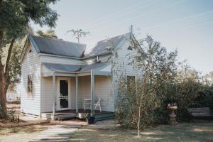 a small white house with a porch at Dubuque Bed and Breakfast in Numurkah