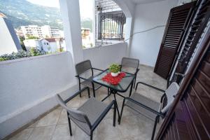 a balcony with a table and chairs and a window at Bologna Apartments in Budva