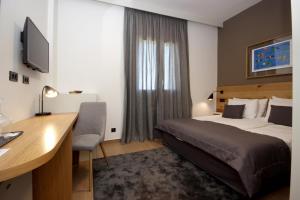ein Hotelzimmer mit einem Bett und einem Schreibtisch mit einem Computer in der Unterkunft Rooms Alla Beccaccia in Fažana
