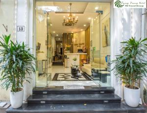 a store front with two potted plants on the stairs at Tung Trang Hotel in Hanoi