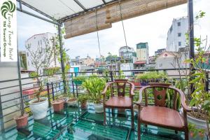 a balcony with chairs and potted plants on it at Tung Trang Hotel in Hanoi