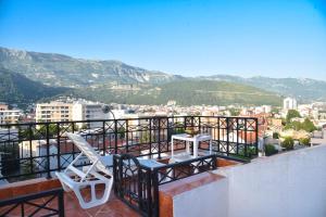 a balcony with two chairs and a view of a city at Bologna Apartments in Budva