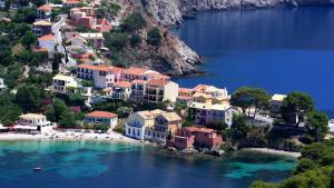 an island in the water with houses and a beach at Pension Gerania in Asos