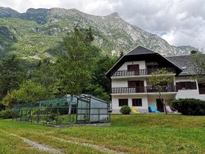 une maison devant laquelle se trouve une serre en verre dans l'établissement Apartment Joži, à Vallée de la Soča