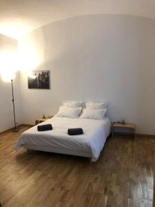 - une chambre dotée d'un grand lit avec des draps et des oreillers blancs dans l'établissement Boulevard GRAZIANI, à Bastia