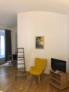 - un salon avec une échelle et une chaise jaune dans l'établissement Boulevard GRAZIANI, à Bastia