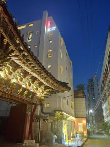 ソウルにあるTong Tong Petit Hotelの看板が目の前にある高層ビル