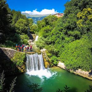 a group of people riding bikes on a bridge over a waterfall at appartamento turistico il colle del nibbio in Torricella Peligna