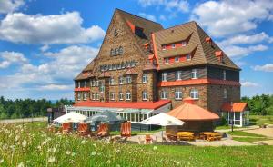 ein großes Gebäude mit Stühlen und Tischen davor in der Unterkunft Hotel Sachsenbaude Oberwiesenthal in Kurort Oberwiesenthal