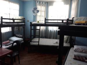 cv bed n bath san juan في Dalumpinas Oeste: غرفة بها ثلاثة أسرة بطابقين وطاولة