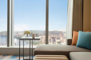 a living room with a couch and a large window at Hyatt Place Liuzhou in Liuzhou