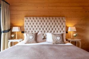 um quarto com uma grande cama branca com almofadas em Chalet Melchior em Villars-sur-Ollon