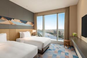 een hotelkamer met 2 bedden en een groot raam bij Hyatt Place Liuzhou in Liuzhou