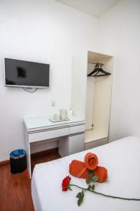 a bedroom with a bed with an orange flower on it at Rose Cottage Hotel Taman Nusa Cemerlang in Gelang Patah