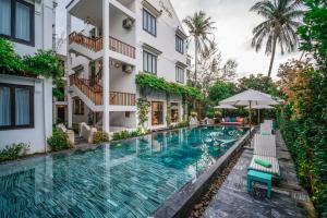 uma piscina em frente a um edifício em Tra Que Mansion em Hoi An