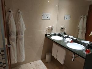a bathroom with two sinks and a large mirror at Hotel RH Sorolla Centro in Valencia