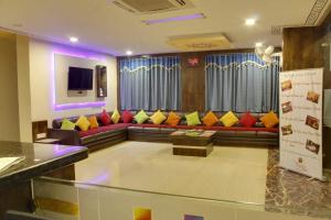 a living room with a couch with colorful pillows at Hotel Riddhi Inn in Udaipur