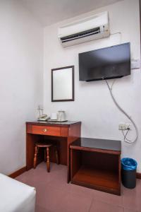 a room with a desk with a sink and a mirror at Rose Cottage Hotel Taman Daya in Johor Bahru