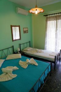 due letti in una stanza con pareti verdi di Drosia Apartments a Asprovalta