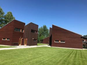 una casa in legno con un prato verde di fronte di Apartmany Resort a Horní Bečva