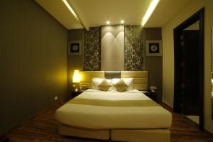 a bedroom with a large bed with two pillows at The Vivaan Hotel & Resorts Karnal in Karnāl
