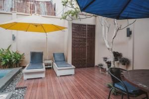 a patio with two chairs and an umbrella at RedDoorz Plus @ Tanjung Karang Lampung 2 in Bandar Lampung