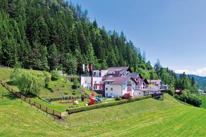 eine Gruppe von Häusern auf einem Hügel auf einem Feld in der Unterkunft Kogler’s Pfeffermühle Hotel & Restaurant in Sankt Urban