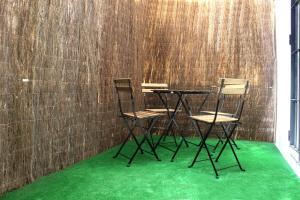 dwa krzesła i stół z zielonym dywanem w obiekcie Plaza de España building w Kadyksie