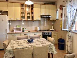 eine Küche mit Tisch und Stühlen und einem Kühlschrank in der Unterkunft Apartment DAZ in Makarska + 13 Fotos