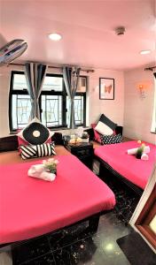 two beds in a room with red cushions at Cebu Inn in Hong Kong