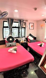 2 camas en una habitación con cojines rojos en Cebu Inn, en Hong Kong
