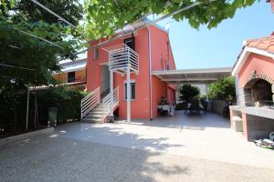 un edificio rosso con scale di fronte di Apartment Mihaela a Rovigno (Rovinj)