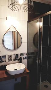 une salle de bain avec un lavabo et un miroir dans l'établissement Apartament z tarasem na dachu B22, à Rowy