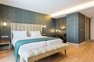 a bedroom with a large white bed and a blue wall at Acta The Avenue in Porto