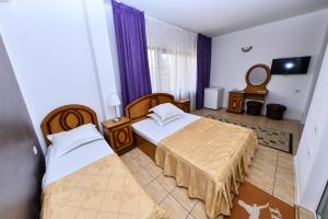 a hotel room with two beds and a mirror at Vila Eden in Eforie Nord
