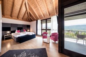 a hotel room with a bed and a balcony at Felderer Boutiquehotel in Caldaro