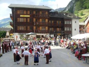 un grupo de personas bailando delante de una multitud en Hôtel des Haudères, en Haudères