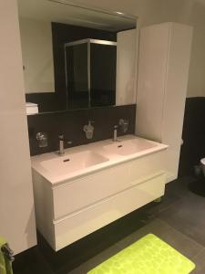 a bathroom with a white sink and a mirror at Appartement Butterfly in Saas-Grund