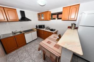 eine Küche mit Holzschränken und einem weißen Kühlschrank in der Unterkunft Vila Eden in Eforie Nord