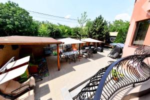 an outdoor patio with tables and chairs and umbrellas at Vila Eden in Eforie Nord