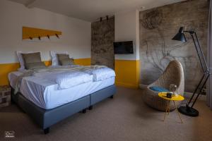 a bedroom with a bed and a table and a chair at B&B La Corderie in Hamme