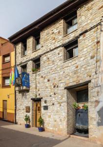 a brick building with flags on the side of it at ALBERGUE SAN SATURNINO in Ventosa