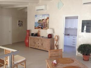 a living room with a table and a kitchen at La casa di Pier in Olbia